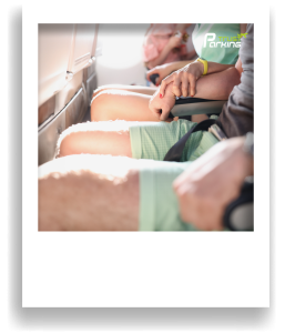 TrustParking | Blog: Flugangst überwinden: Ihre Tipps für entspanntes Reisen ab Flughafen Köln/Bonn (Nahaufnahme von einer Frau und einem Mann im Flugzeug, nebeneinander sitzend, während sich beide an den Sitz krallen)